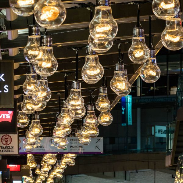 Strings of Edison light bulb decoration hanging from the ceiling inside a shopping center.