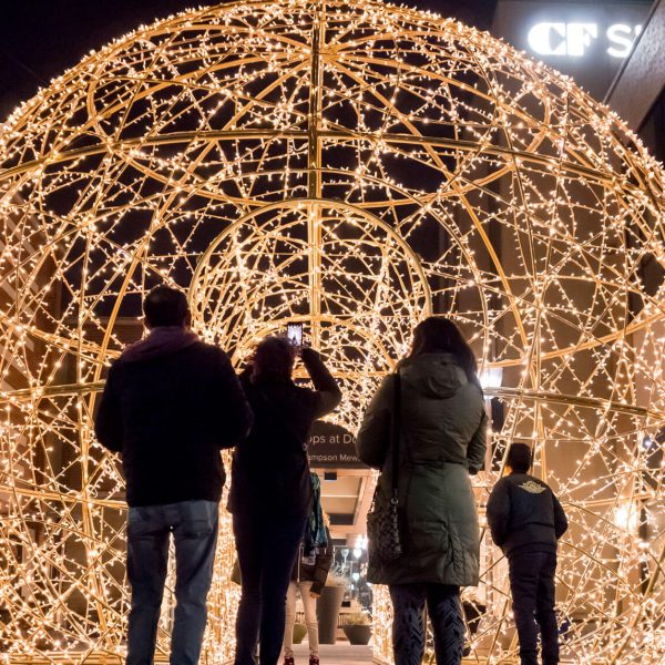 People in front of a giant walkthrough light ornament.