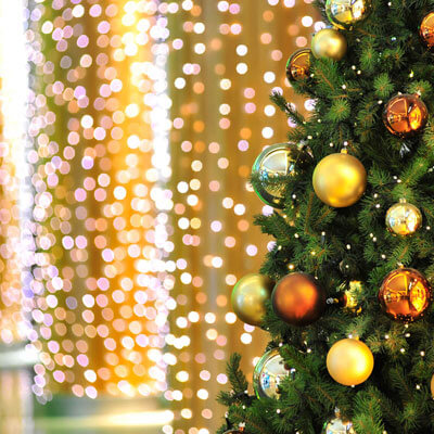 Close up view of light greenery garland with shiny and dull golden baubles.