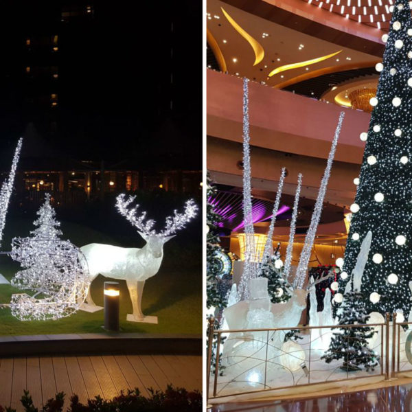 Illuminated fiber glass sculptures of white reindeer and icicles with light lettering "C O D" and fiberglass sculptures of reindeer, snowmen and icicles between with white light balls decorated trees inside the resort, hotel & casino City of Dreams in the city of Manila, Philippines.