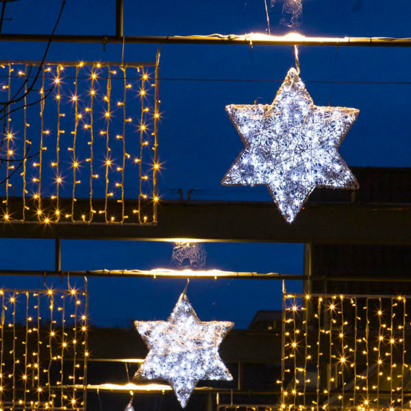 Light compositon with drape lite and white organic stars across a street in the city of Esslingen, Germany.