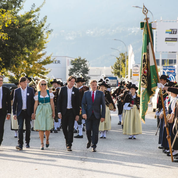 Company founders walking along the honor guard of the marksman-company celebrating the 20th anniversary of MK Illumination in the city of Innsbruck, Austria.