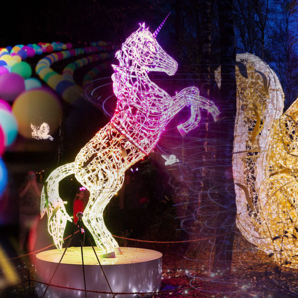 Picture composition of colorful light balls and light sculptures of a rearing up unicorn and a squirrel.
